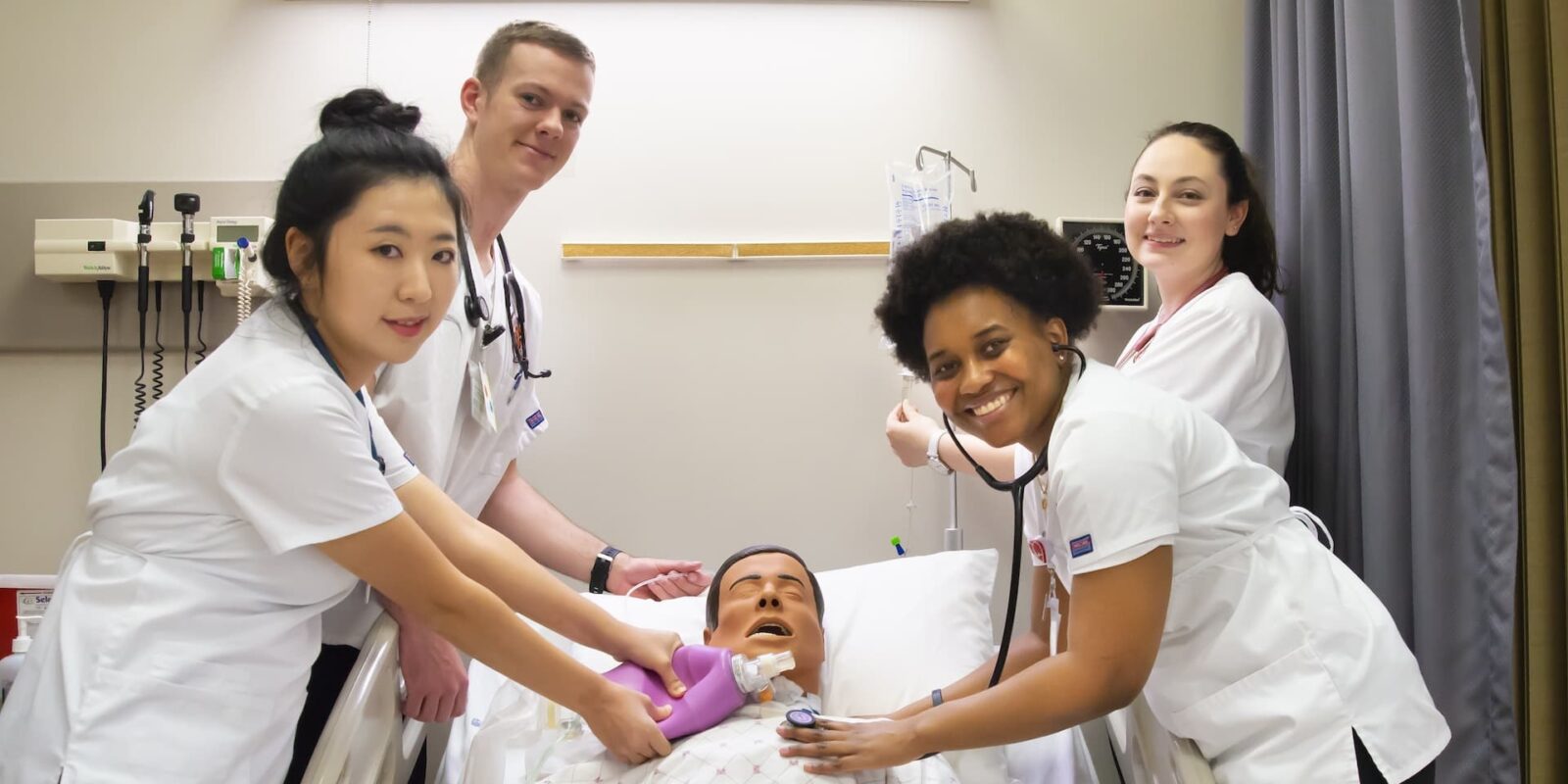nursing students practicing skills on hospital dummy